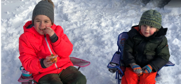 Two girls enjoying snacks on a winter day