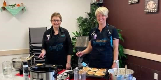 Synergy staff serving breakfast at a LEAP event