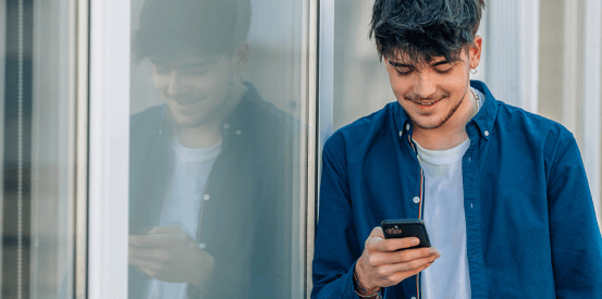 College student looking at their mobile phone on the street