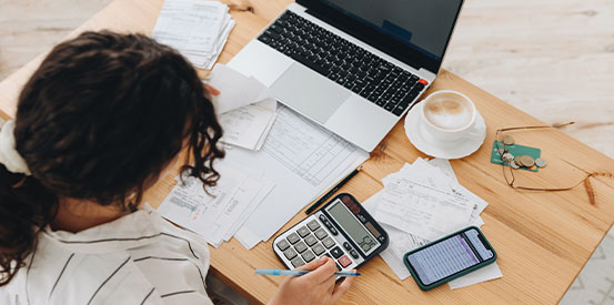 Top view of a woman planning a budget to save some money.