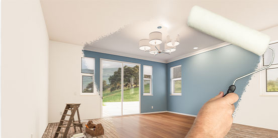 Before and after effect of a painting roller to reveal room with fresh blue paint and new floors.