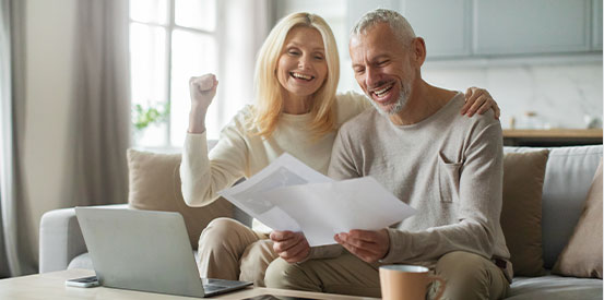 couple-reviewing-documents-on-couch couple-reviewing-documents-on-couch